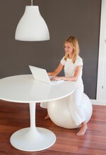 A Girl Wearing White Using A White Laptop Computer In A Room Furnished In White; Benalamadena Costa, Malaga, Andalusia, Spain