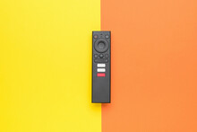 Modern TV Remote Control On A Yellow-orange Background. TV Management Concept.