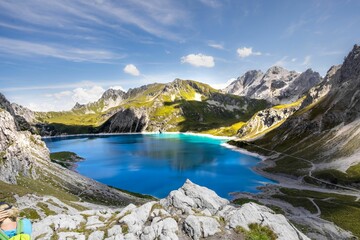 Sticker - Tranquil Lunersee lake surrounded by lush green grass and jagged mountains in Austria