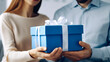 © ADDICTIVE STOCK - Generative AI image of crop anonymous couple holding small gift box wrapped with white ribbon against blurred background