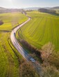 © Anselm Schwietzke/Wirestock Creators - Aerial view of a road in a farm field during the sunset in Germany