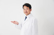 © siro46 - 左側を手の平で指す中年の医師　白背景