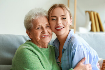 Poster - Young woman and her grandmother hugging at home, closeup