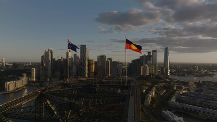 Wall Mural - Australian and Aboriginal Flag on Top of Sydney Harbor Bridge, Golden Hour Sunset, With Sydney City Skyline in Background, Aerial