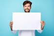 a handsome white man holding a blank placard sign poster paper in his hands. empty space for editing and ads. isolated on pastel blue background. Generative AI