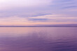 Colorful sky background on sunset or sunrise, purple pastel color clouds and surface water on lake Ik. Nature abstract composition with reflections on water, natural blue purple shades of skyline