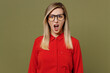Young angry mad sad indignant woman she wears red shirt casual clothes glasses look camera with opened mouth scream shout isolated on plain pastel green background studio portrait. Lifestyle concept.