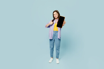 Wall Mural - Full body young happy woman wears purple shirt yellow t-shirt casual clothes hold in hand use mobile cell phone with blank screen workspace area isolated on plain pastel light blue background studio.