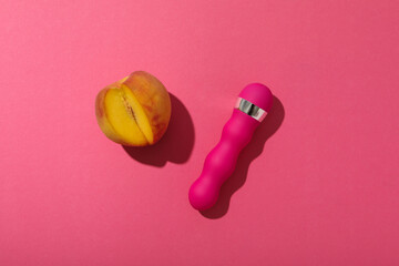 Wall Mural - Pink vibrator with a peach on a pink background.