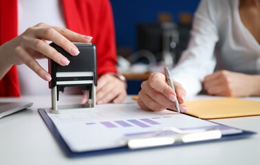 Wall Mural - Business women signing document and certifying seal closeup. Signing contracts concept