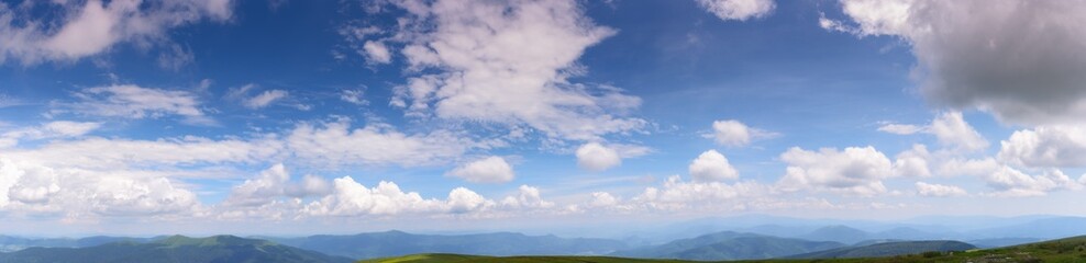 Wall Mural - gorgeous panorama of a blue sky with fluffy clouds. amazing cloudscape above the mountain range on a
