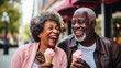 © ReneLa/Peopleimages - AI - Happy retired senior couple with icecream in city. Fun travel activity
