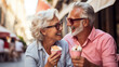 © ReneLa/Peopleimages - AI - Happy retired senior couple with icecream in city. Fun travel activity