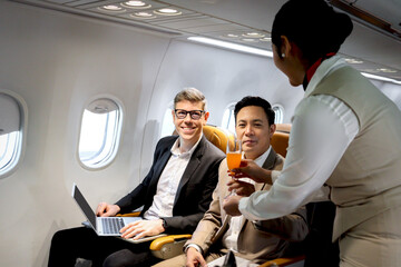 Businessman in comfortable seat inside airplane, female cabin crew air hostess serving orange juice drink, flight attendant take care passengers on aircraft, airline service job and transportation.