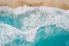 Surfer Walk On Sandy Beach With Blue Ocean And Waves. Aerial View