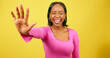 © Meeko Media - Excited young woman holds up hand, high five close up, yellow studio shoot