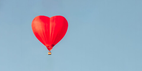 Wall Mural - Hot air balloon in shape of heart in a blue sky. Space for text