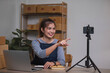 © wichayada - Asian blogger review products and video camera on her phone, sell them online, and showcase her products online on social media. ecommerce business live streaming vlog new normal concept