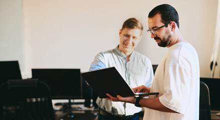 Wall Mural - Portrait of two professional male programmers working on computer in diverse offices. Modern IT technologies, development of artificial intelligence, programs, applications and video games concept