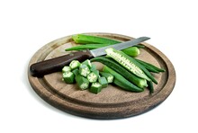 Okra Slice And Knife On Wooden Tray Isolated On White Background