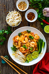 Sticker - Pad Thai with prawns and rice noodles in peanut and tamarind sauce on wooden table
