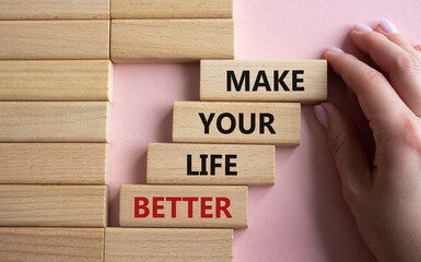 Make your Life Better symbol. Concept word Make your Life Better on wooden blocks. Beautiful pink background. Businessman hand. Business and Make your Life Better concept. Copy space
