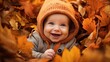 © Banana Images - Baby in autumn leaves happy smiling to camera, kids during fall weather