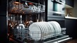 © GulArt - Dish washer machine full of clean kitchen utensils on a blurred modern kitchen background