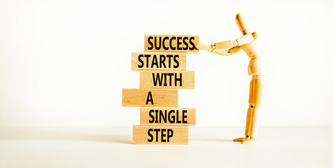 Wall Mural - Success symbol. Concept words Success starts with a single step on wooden block. Beautiful white table white background. Businessman icon. Business success starts with single step concept. Copy space.