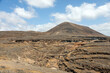Erloschender Vulkan auf Lanzarote mit steiniger Landschaft im Vordergrund
