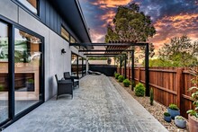 modern home patio area with seating and wood privacy fence at dusk