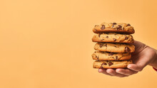 Hand Holding Chocolate Chip Cookies Isolated On Orange Background, Copyspace For Text, American Cookie