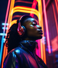 Fashionable Young Black Woman Listening To Music With Headphones On Night City Street With Neon Lights.