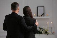 Couple Mourning Indoors, Back View And Space For Text. Funeral Ceremony