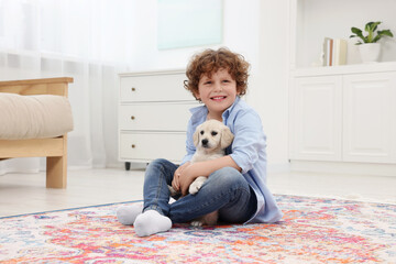 Sticker - Little boy with cute puppy on carpet at home