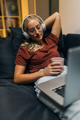 Wall Mural - Tired woman fell asleep on the sofa with laptop on her lap.