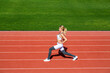 © Yevhen - Physical training girl. Fit girl do outward lunging. Physical training education. Sports lesson. Female runner stretching before workout. Sports exercises and stretching in the stadium
