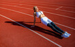 © Yevhen - Sports exercises and stretching in the stadium. Physical training girl. Fit girl do outward lunging. Physical training education. Sports lesson. Female runner stretching before workout