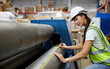 © offsuperphoto - female factory worker using tape measure and measuring the length of the steel pipe in the factory