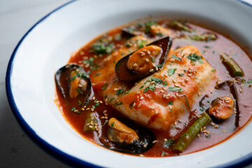 Wall Mural - Hake with tomato sauce and mussels. Traditional recipe from northern Spain.