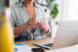 © Studio Marmellata - Crop anonymous female executive in smart casual sitting at table and writing notes in notebook while working in modern office