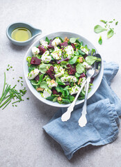 Light dietetic salad with goat cheese, beetroot pieces, walnuts, olive oil and herbs. Mediterranean salads, typical dishes of Spain, France, Turkey and Italy, front view 