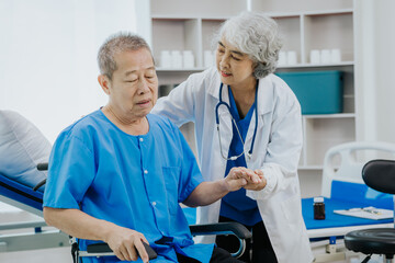 Asian female physical therapist works with an elderly woman to walk with a walker.