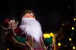 © stockyes - Santa Claus doll on christmas background with bokeh lights.