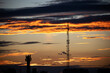 © Elena - Landscape Sky. Dark, clear silhouettes of the roofs of houses with chimneys and pipes in the rays of the setting sun.