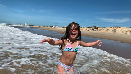 Joyful ecstatic happy child girl at beach