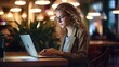 © Konrad - Young Woman Working on Laptop in Café - Freelancer or Female Student Smiling at Camera