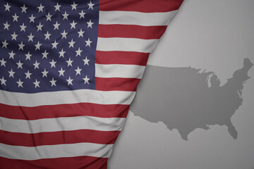 Wall Mural - big waving national colorful flag and map of united states of america on the gray background.