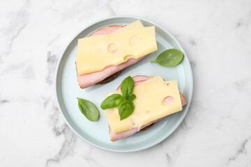 Wall Mural - Delicious sandwiches with ham and cheese on white marble table, top view