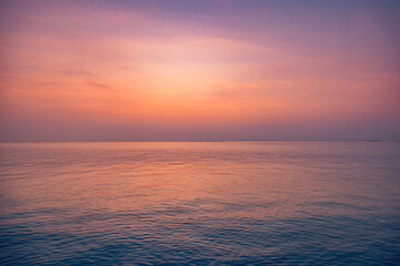 Beautiful closeup sea water surface. Sunset sunrise light orange gold blue colors calm soft waves relaxing horizon. Dream fantasy majestic seascape sky. Tranquil peaceful nature pattern, Mediterranean